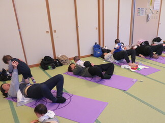 写真：2月26日活動風景・ママのお腹の上で一緒にポーズ！